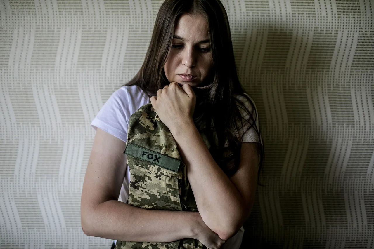 Svitlana leaning against a wall in her home