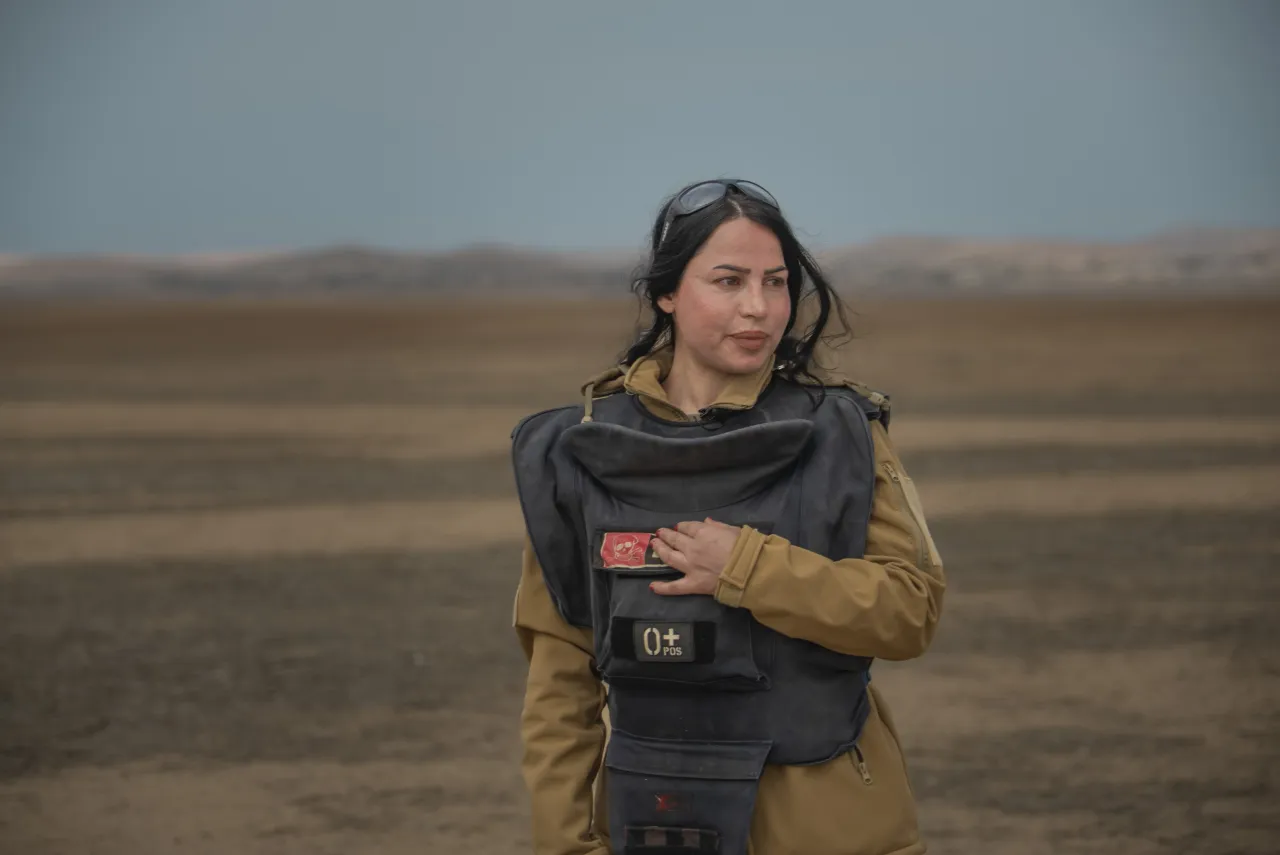 Noora Murad, a deminer wearing protective gear, looks at the camera from a mine field in Iraq. Mike KHALAF/ICRC Noora Murad, a deminer wearing protective gear, looks at the camera from a mine field in Iraq.